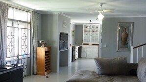 Una sala de estar con un sofá, una mesa de centro y una cocina al fondo.