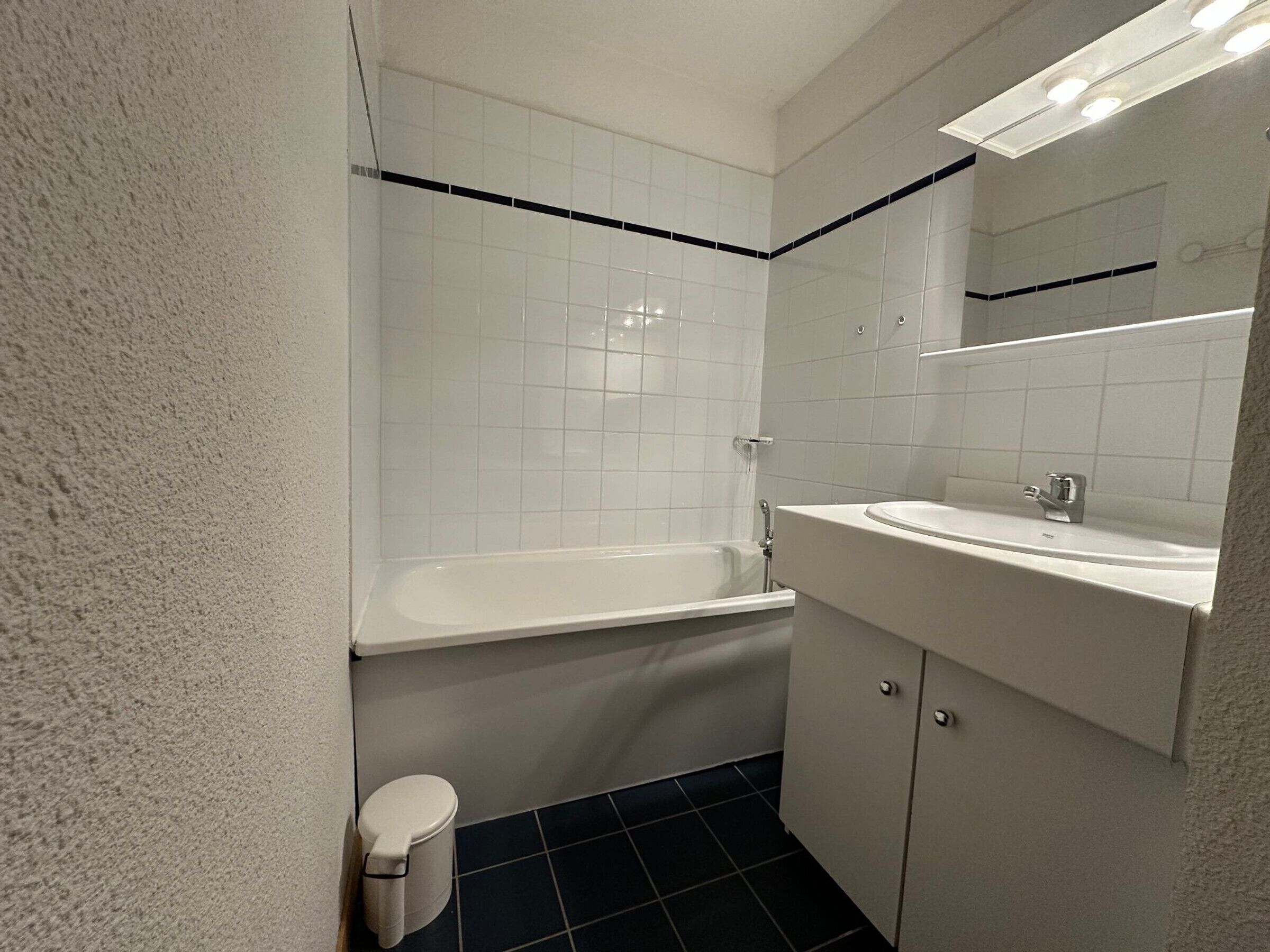 Un baño con una bañera blanca, un lavamanos y un inodoro.