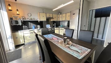 Et moderne køkken med spiseplads, udstyret med mikrobølgeovn, komfur og køleskab.