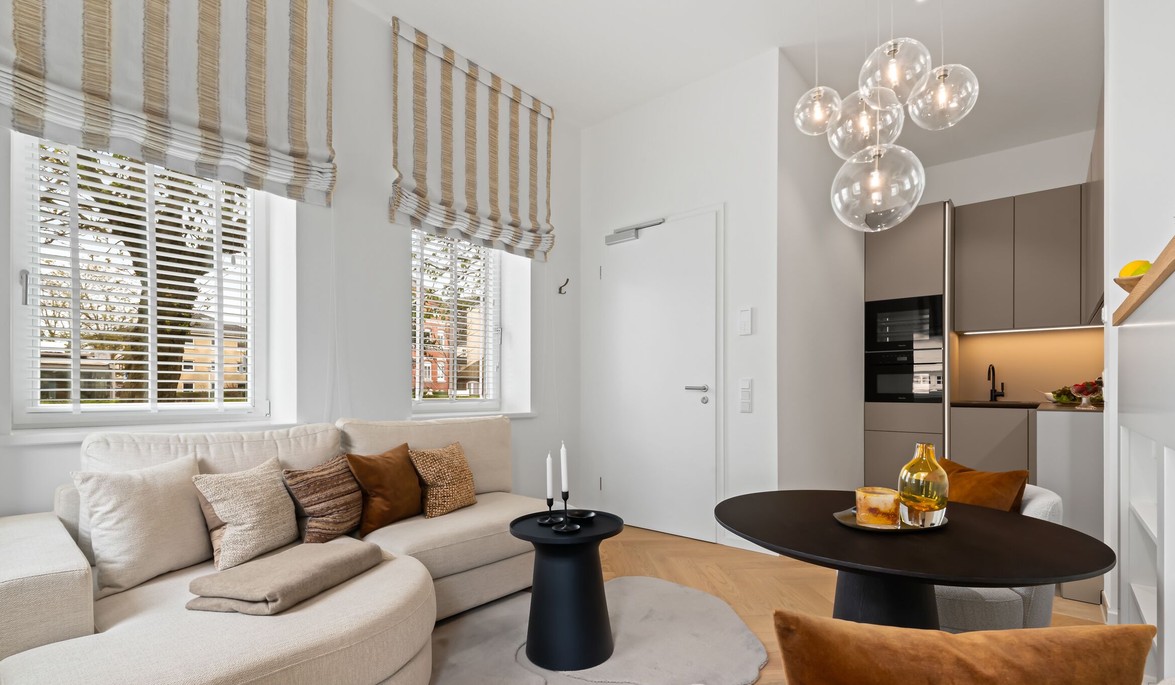 A modern living room with a sofa, a round table, and a chandelier.