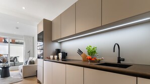 Een moderne keuken met een strak design, een inbouwoven en een groot raam met uitzicht op de stad.