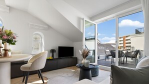 Een modern appartement met balkon, een eethoek en een woongedeelte.
