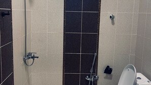 Ein Badezimmer mit Toilette, Dusche und Fenster.