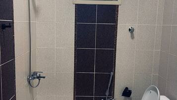 Eenvoudig appartement | Badkamer | Een douche, een haardroger, pantoffels, zeep