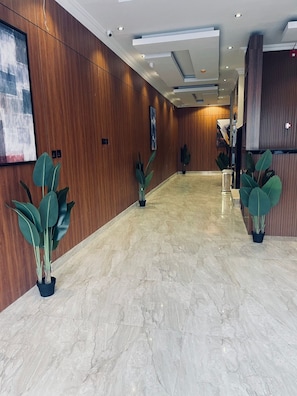 Stunning hallway with polished floors, potted plants, and a beautiful staircase.
