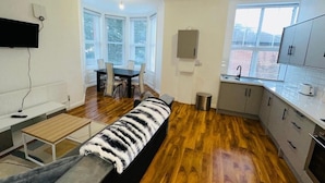 Un appartement moderne doté d’un coin repas, d’une kitchenette et d’une grande fenêtre.
