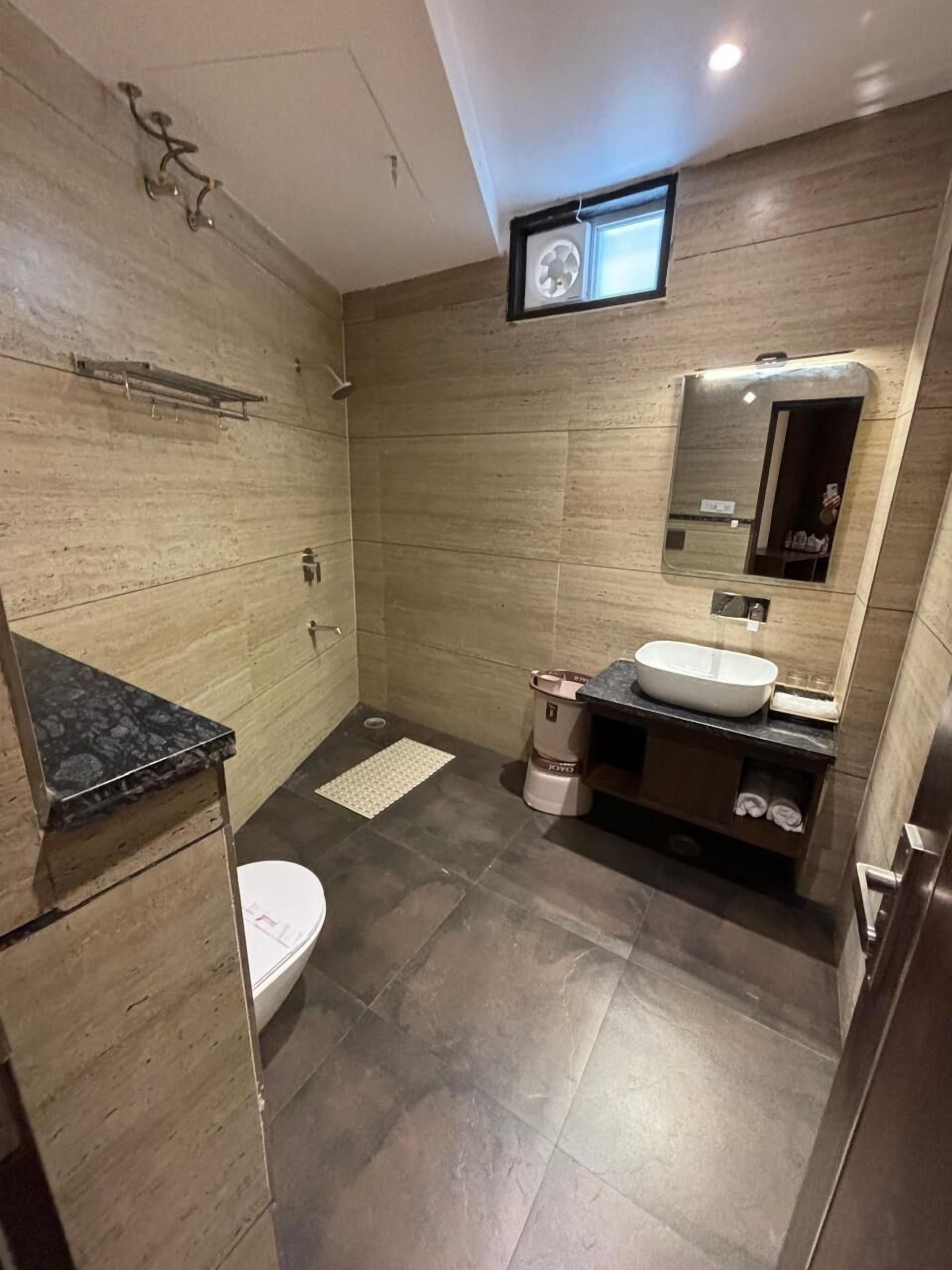 A modern bathroom with a shower, toilet, sink, and vanity.
