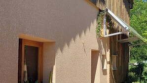 A rustic building with a window displaying potted plants. - Sunset House - Secluded house with panoramic sunset views. (Lahitère)