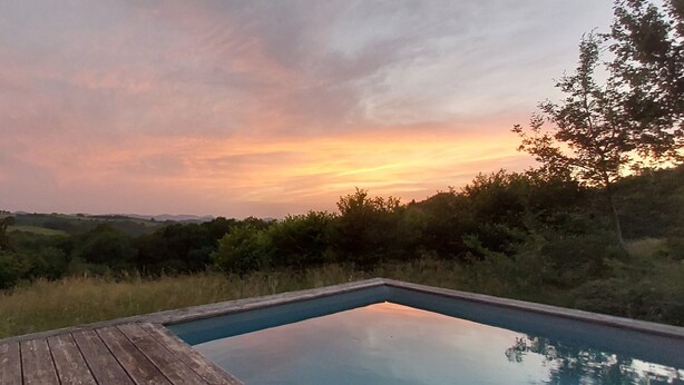 A wooden deck leading to a rectangular swimming pool with a sunset view. - Sunset House - Secluded house with panoramic sunset views. (Lahitère)
