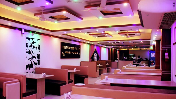 A modern restaurant interior with booths and tables, ceiling lights, and a sign indicating a Russian food theme.