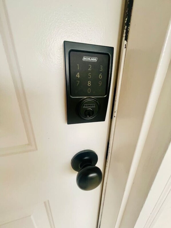 A door with a numeric keypad lock and a round doorknob.