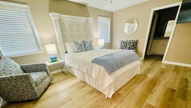 A bedroom with a bed, a chair, a bedside table, and a window. - Eastgate 14A beautiful townhouse (Hammond)