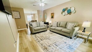A living room with two sofas, a coffee table, and a rug.