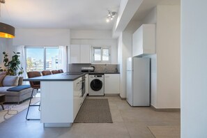 Apartamento luxo, 1 cama Queen e sofá-cama, para não fumantes, vista para a cidade | Cozinha privada | Geladeira grande, fogão, cooktop, talheres/pratos/utensílios de cozinha