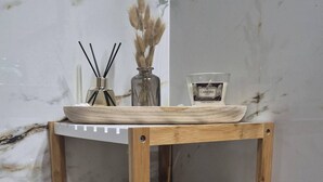Ένα ξύλινο ράφι με τρεις λευκές πετσέτες, τακτικά διπλωμένες.