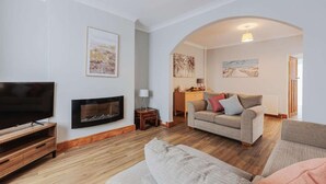 A living room with a TV, fireplace, and a sofa. - Fabulous 3 bedroom Home in Redcar (Redcar)
