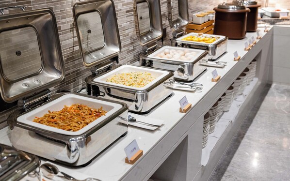 Un bufé con diversas opciones de comida, como arroz, fideos y huevos.