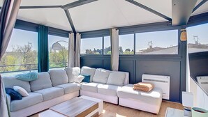 A modern living room with a sectional sofa, a coffee table, and a view of the outdoors.