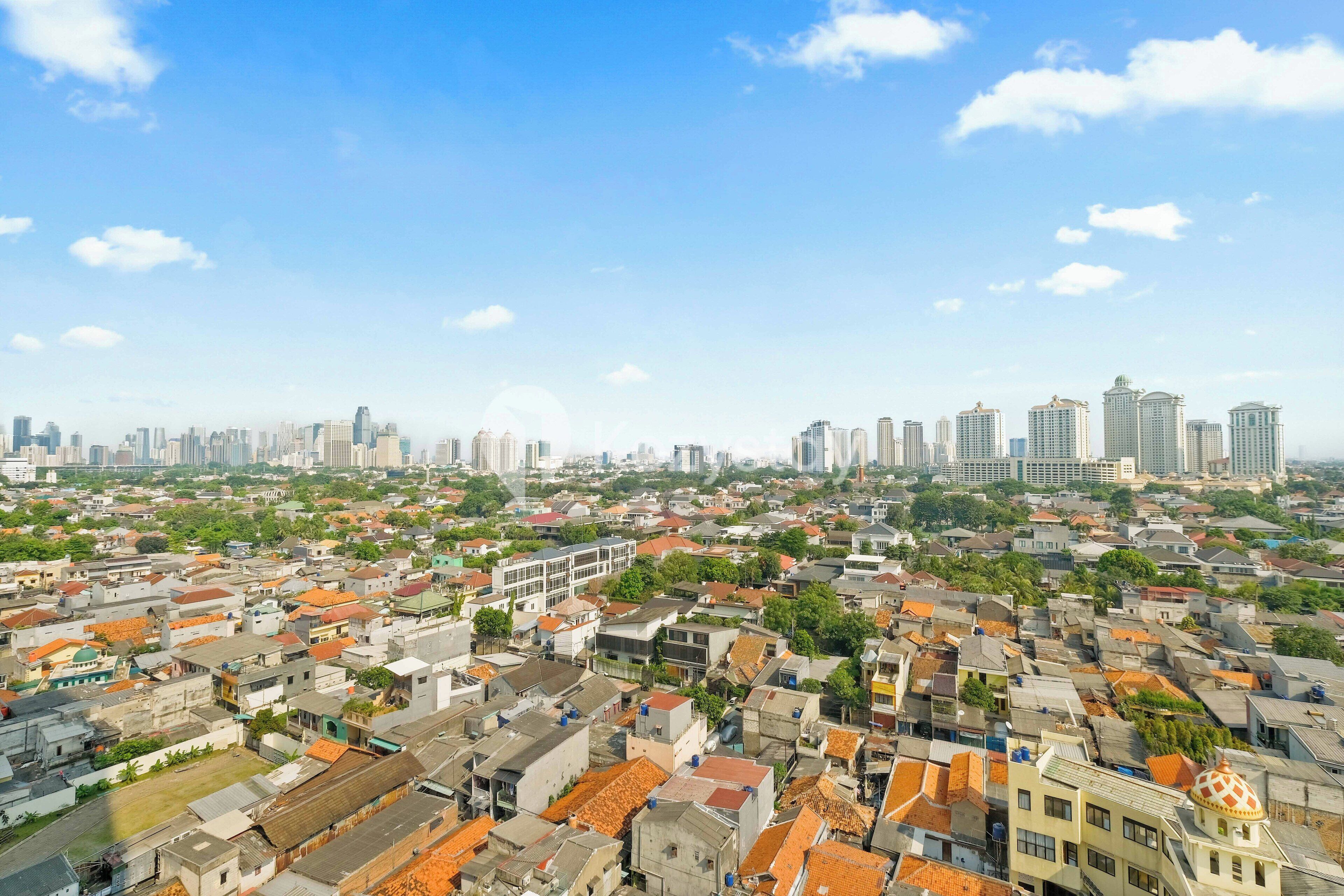 A cityscape with a mix of residential and high-rise buildings, a clear sky, and a distant view of a city skyline.