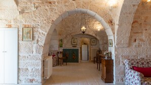 A stone-walled room with a fireplace, a dining table, and chairs.
