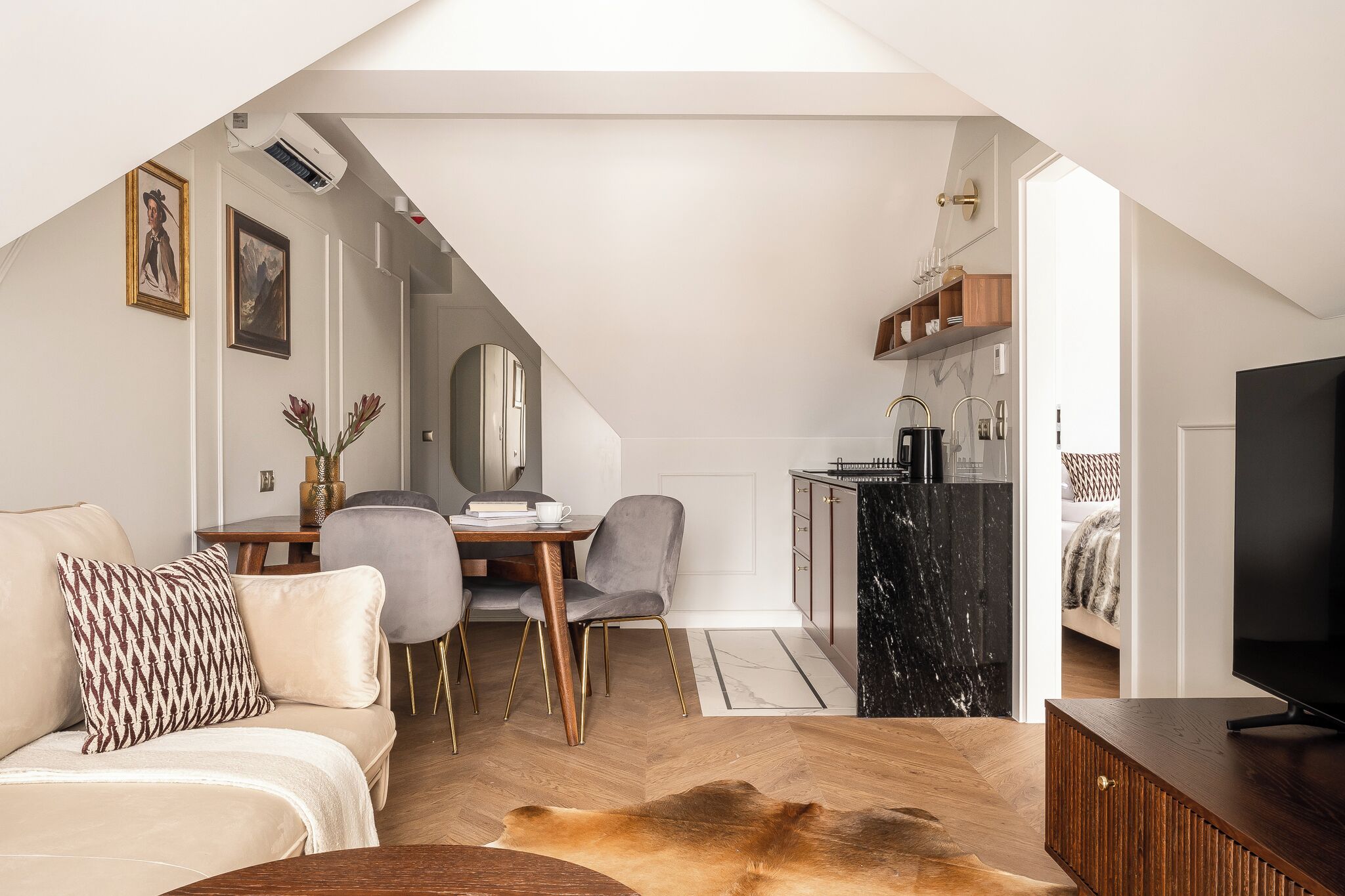 A modern loft apartment with a dining area, kitchen, and living space.