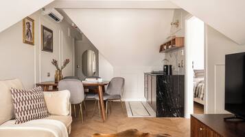 A modern loft apartment with a dining area, kitchen, and living space.