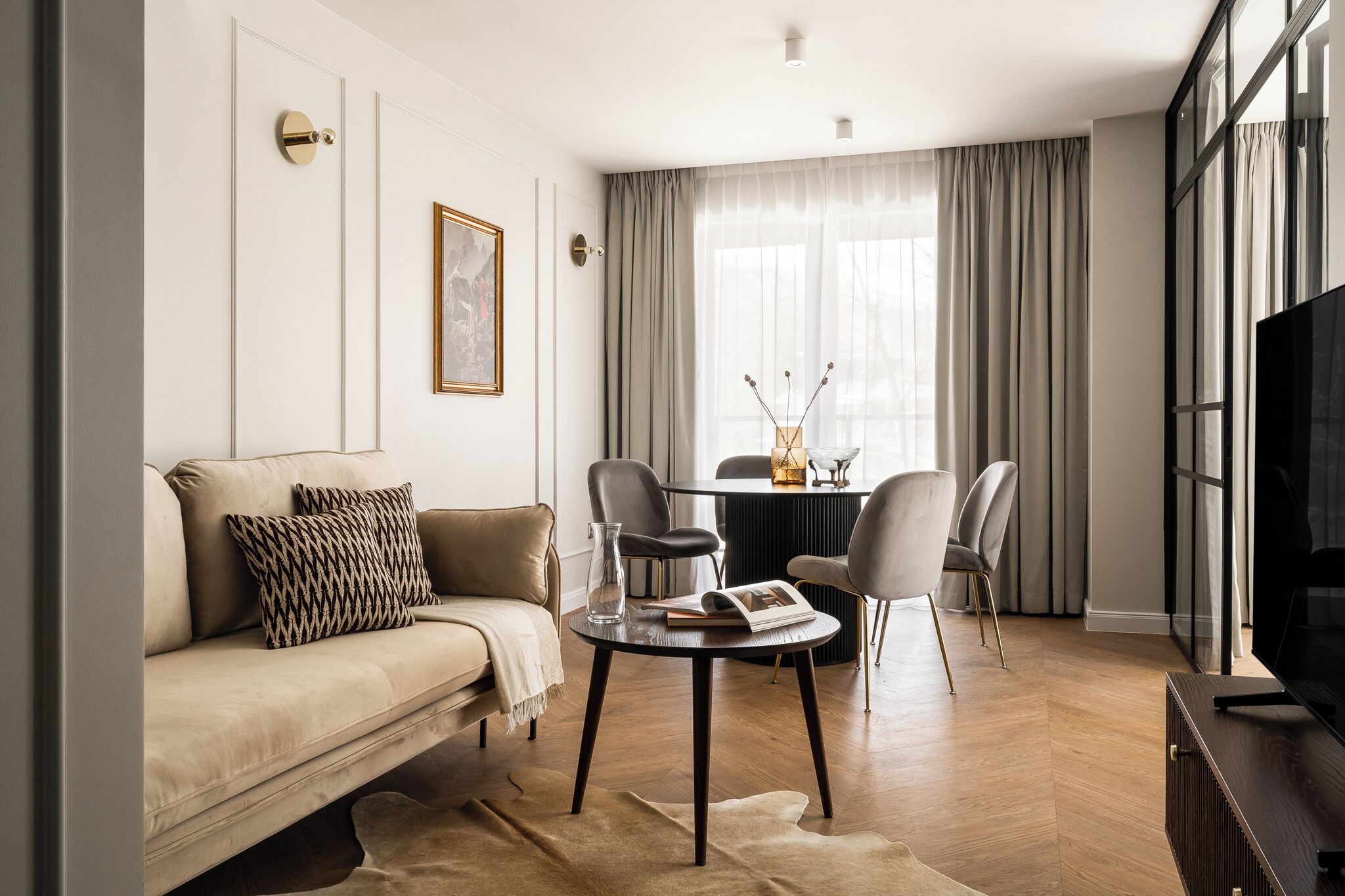 A modern living room with a sofa, a coffee table, and a dining table with chairs.