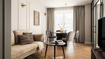 Una sala de estar moderna con un sofá, una mesa de centro y una mesa de comedor con sillas.