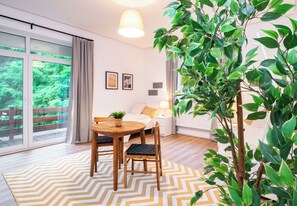 A modern room with a dining area, a bed, and a large window overlooking a deck. - Arbio Monteurzimmer Zossen For 5 People W Parking (Zossen)