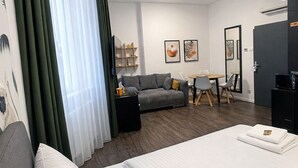 Une chambre d’hôtel avec un lit, un canapé, un bureau et une chaise.