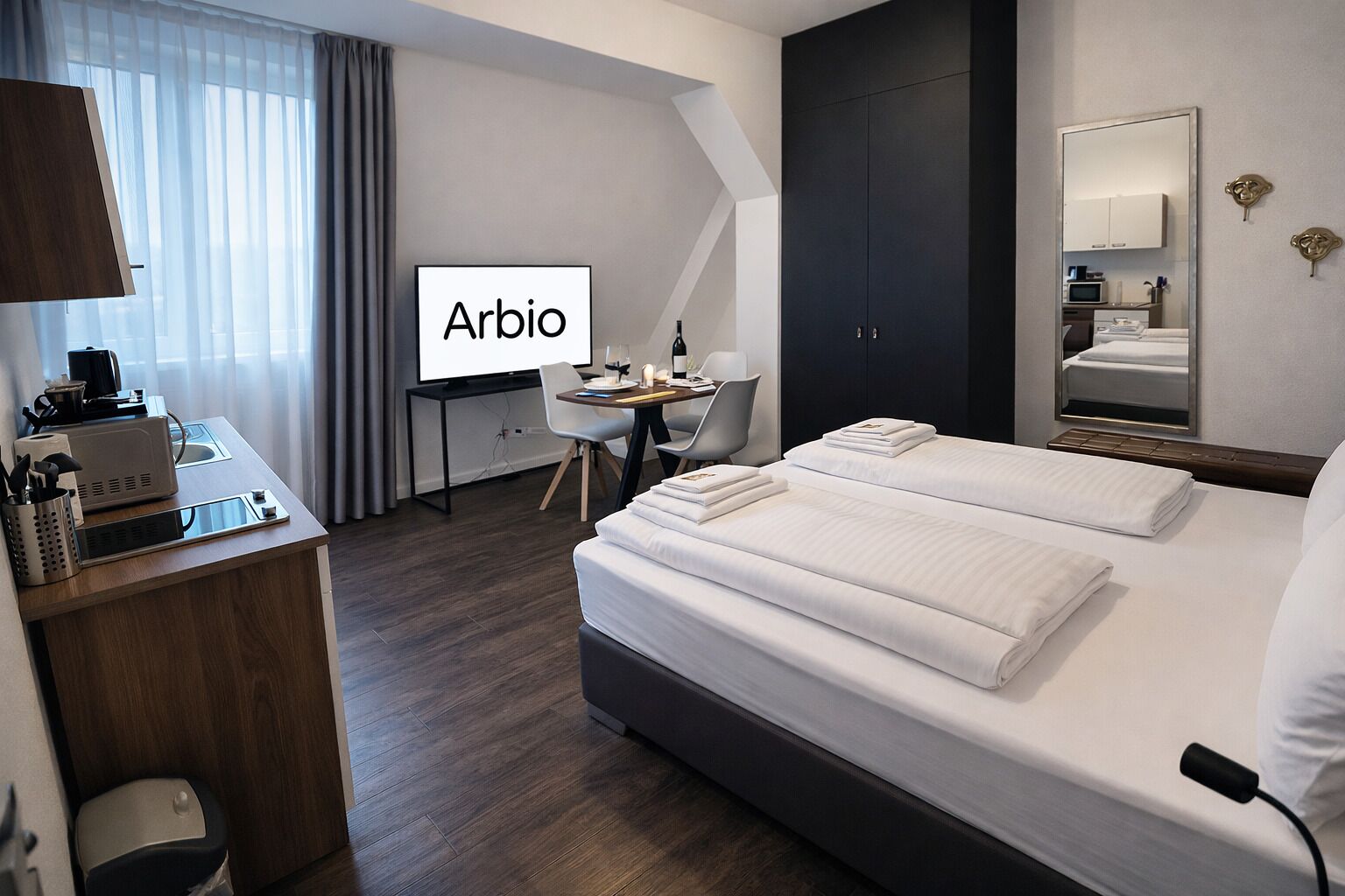 Quarto de hotel com cama, escrivaninha, cadeira e uma TV exibindo 'Arbio'.