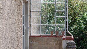 Uma escadaria de concreto leva a uma porta com uma marquise de metal.