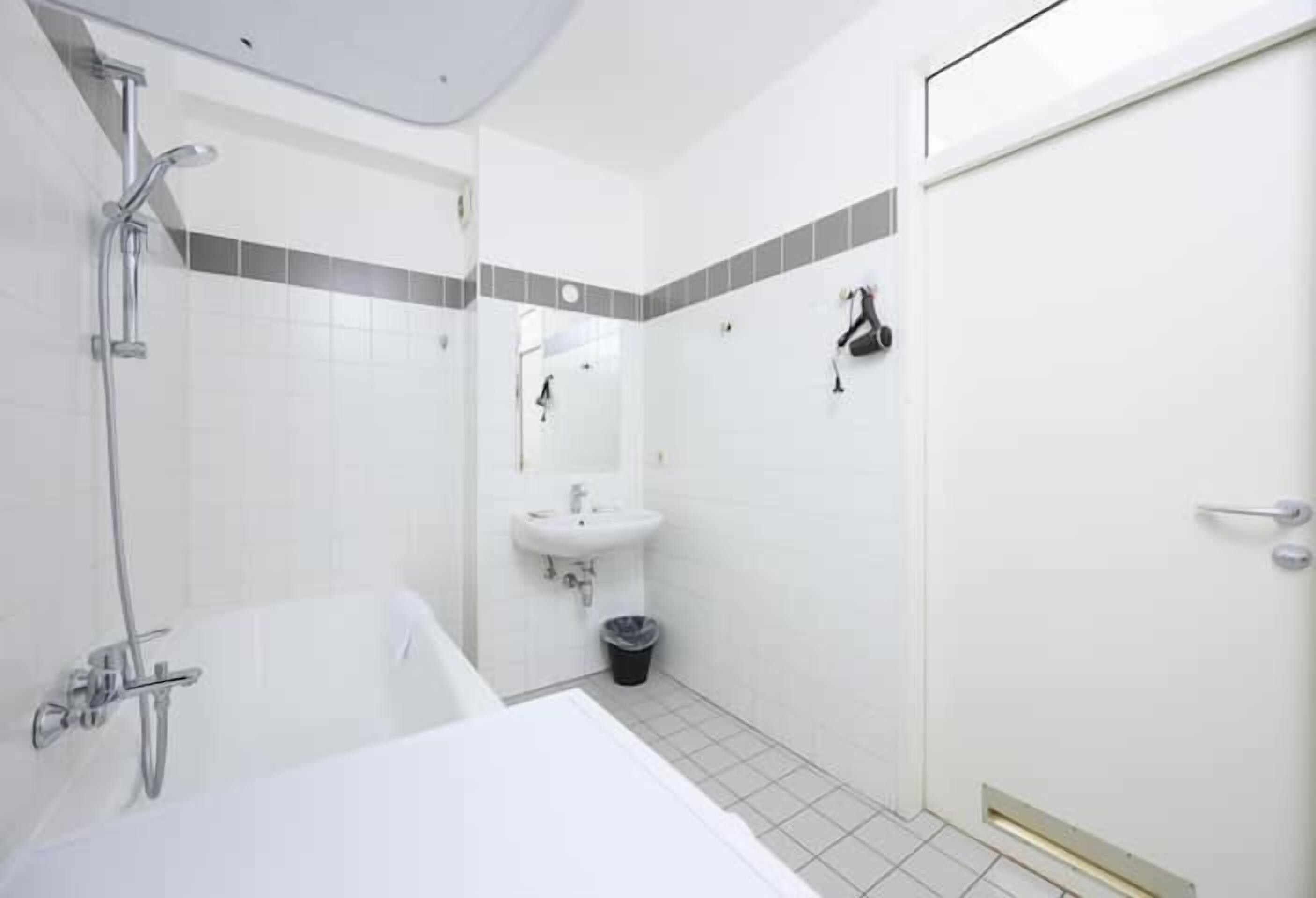 Ein modernes Badezimmer mit Badewanne, Waschbecken und Dusche.