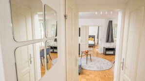 A hallway with a dining area, a bed, and a small table with fruit. - Zum Grazer Uhrturm (Graz)