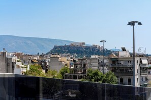 Une vue d’une ville avec, sur une colline, une imposante structure antique, entourée de bâtiments modernes.