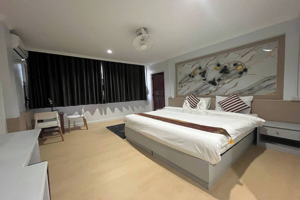 Un dormitorio moderno con una cama grande, un escritorio y una silla.