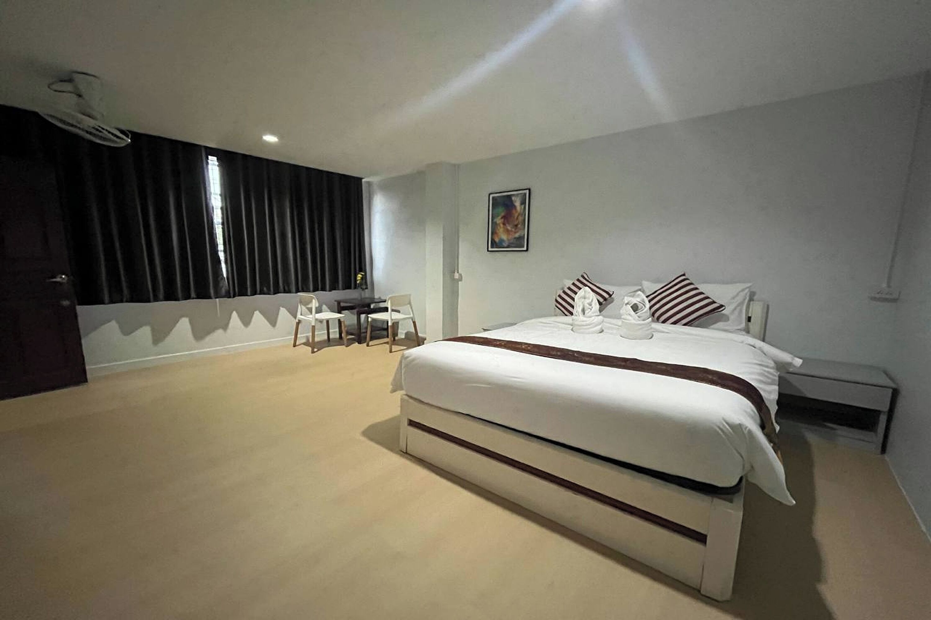 A bedroom with a large bed, a desk, and a chair.