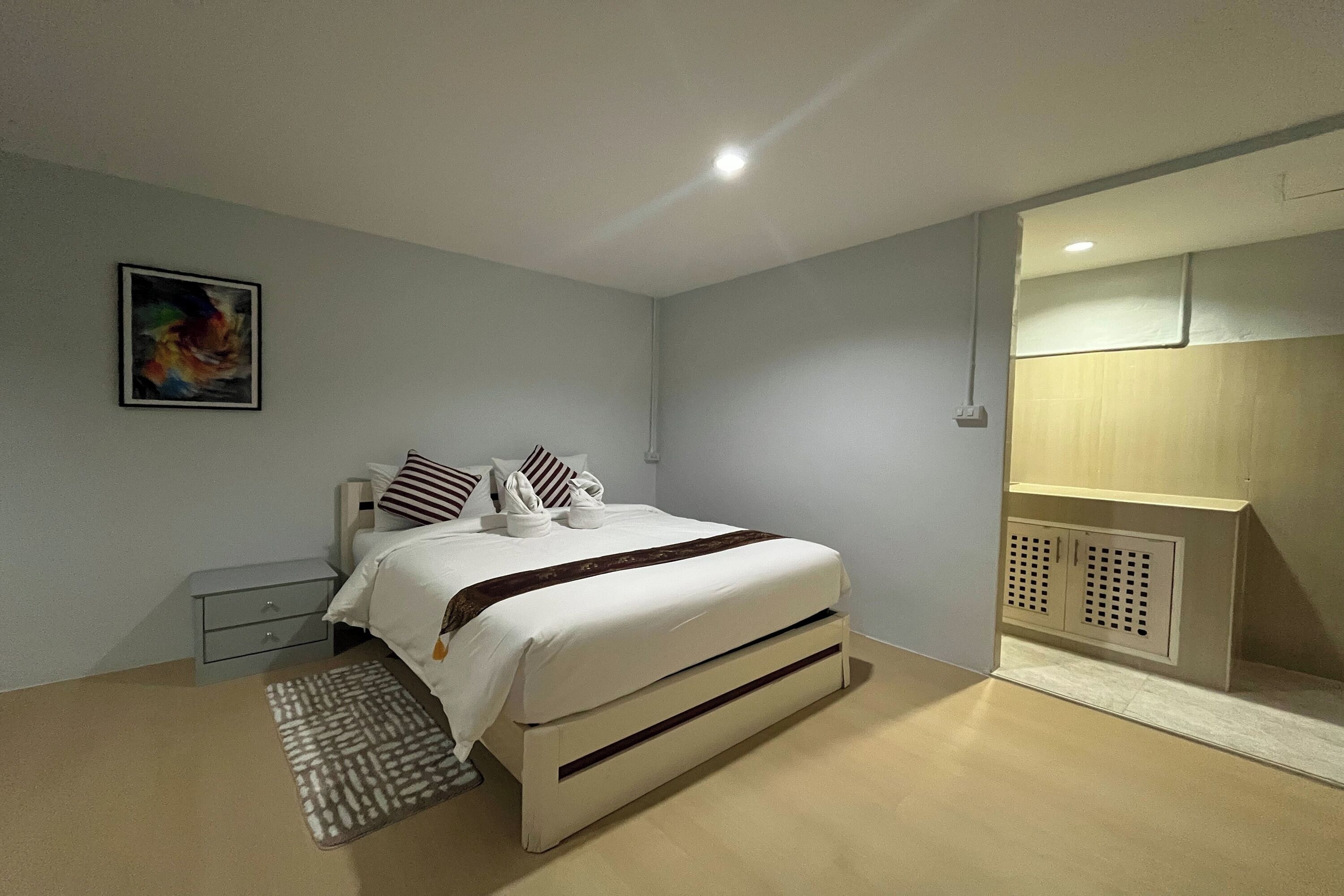 Ein modernes Schlafzimmer mit Bett, Nachttischen, Teppich und Kleiderschrank.