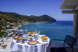 A table set with breakfast items overlooking a coastal view with boats. - Hotel Terme San Michele & SPA, WorldHotels Distinctive Adults Only (Sant'Angelo)