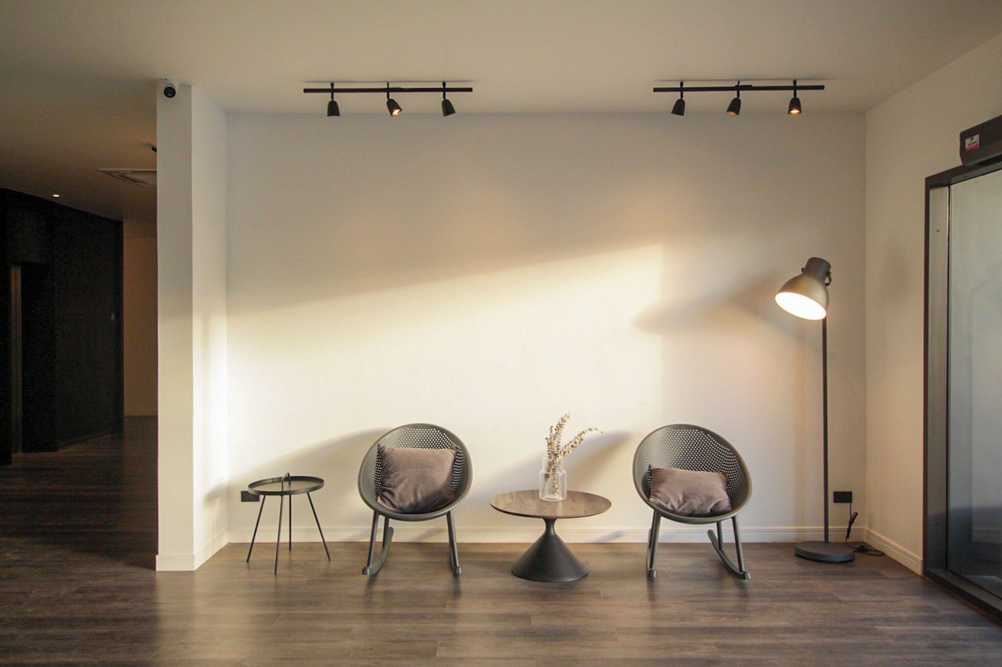 Un intérieur moderne avec deux chaises, une petite table ronde et un lampadaire.