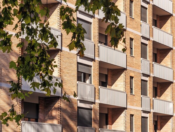 A multi-story building with a brick facade and balconies. - Numa Rome Trastevere (Rome)