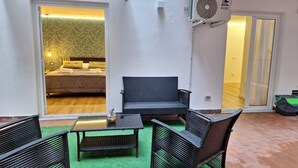 A room with a bed, a table, and two chairs. There is a sliding door leading to another room. - Charming 1-bedroom apartment in wonderful Palermo with AC, WiFi (Palermo)