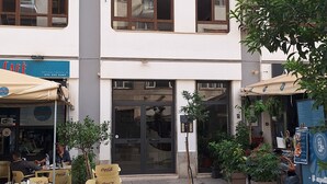 A building with multiple floors, outdoor seating area with yellow chairs, and potted plants. - Charming 1-bedroom apartment in wonderful Palermo with AC, WiFi (Palermo)