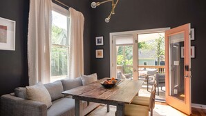Un salon moderne avec un canapé, une table en bois et une vue sur l’extérieur grâce à une porte-fenêtre coulissante.