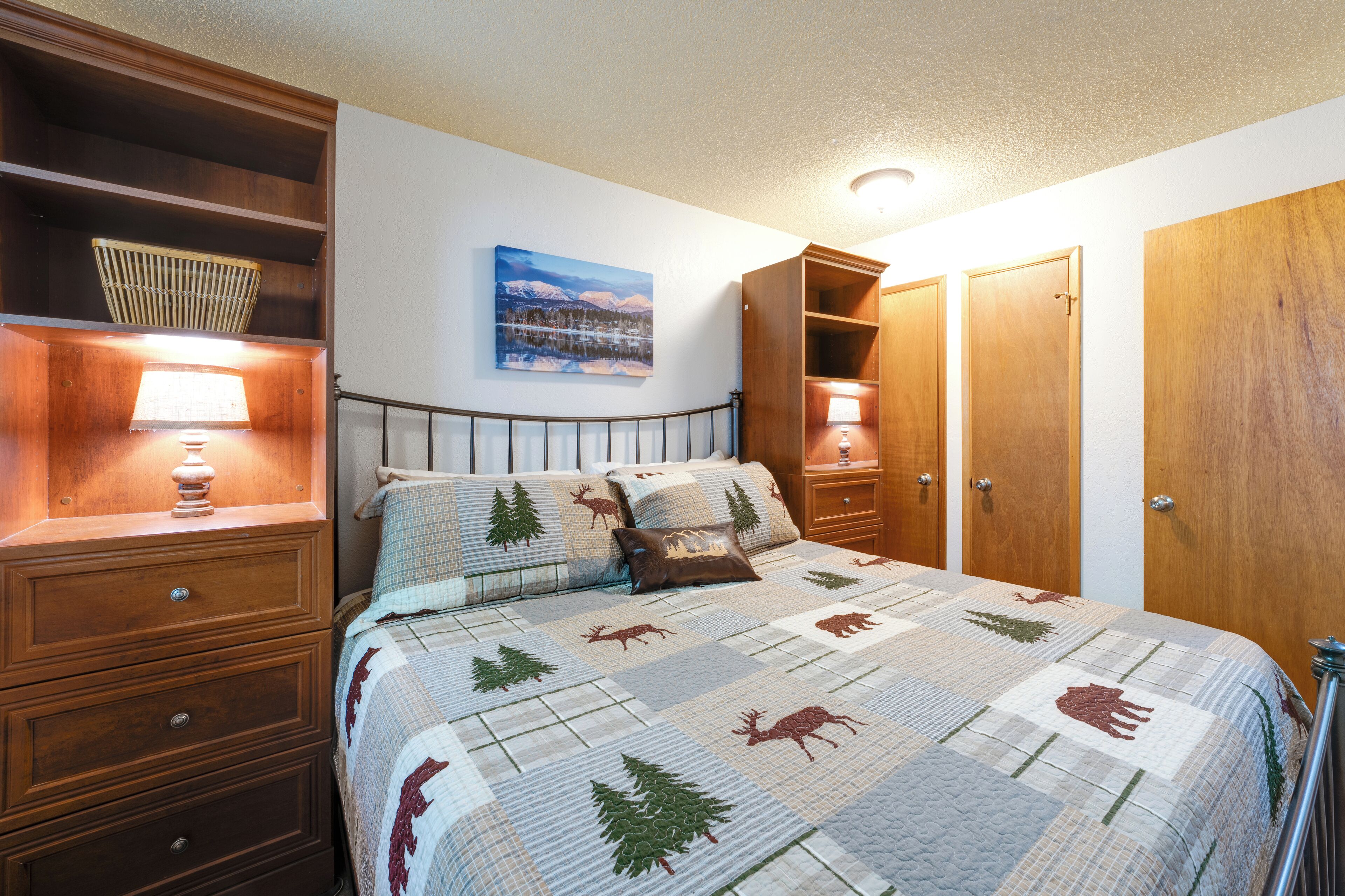 A bedroom with a bed, wooden nightstands, a dresser, and a wardrobe.
