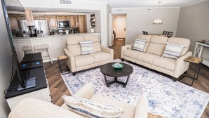 Ein Wohnzimmer mit zwei beigefarbenen Sofas, einem Couchtisch und einem Teppich.