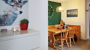 A dining area with a wooden table and chairs, a hanging light fixture, and a wall-mounted clock. - Casa Polsa "1964" - #02
Holiday Home in the mountains (Polsa)
