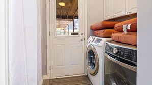 A laundry room with a washing machine, dryer, and stacked towels.