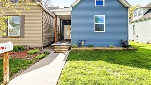 A residential area with a blue house, a brown house, and a mailbox.