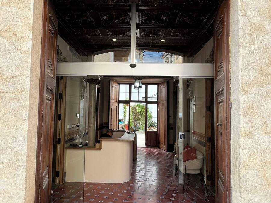 A reception area with a tiled floor, a reception desk, and a view of the outside.